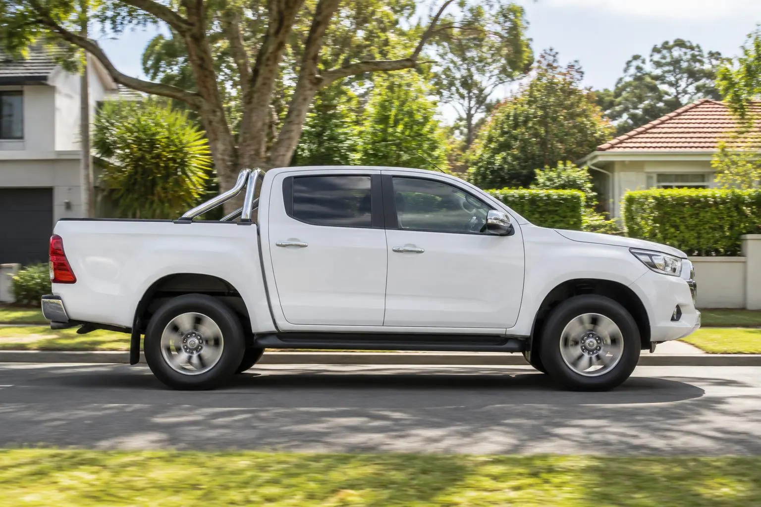 White pest control ute driving on a suburban Sydney road